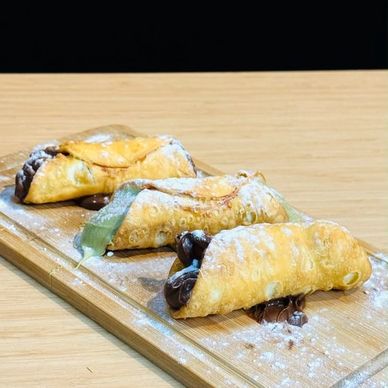 Cannoli recheados finalizados com açúcar de confeiteiro